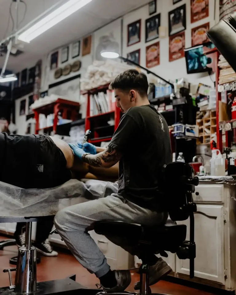Tattoo artist working in a studio session using LucentDesk, a free tattoo booking app