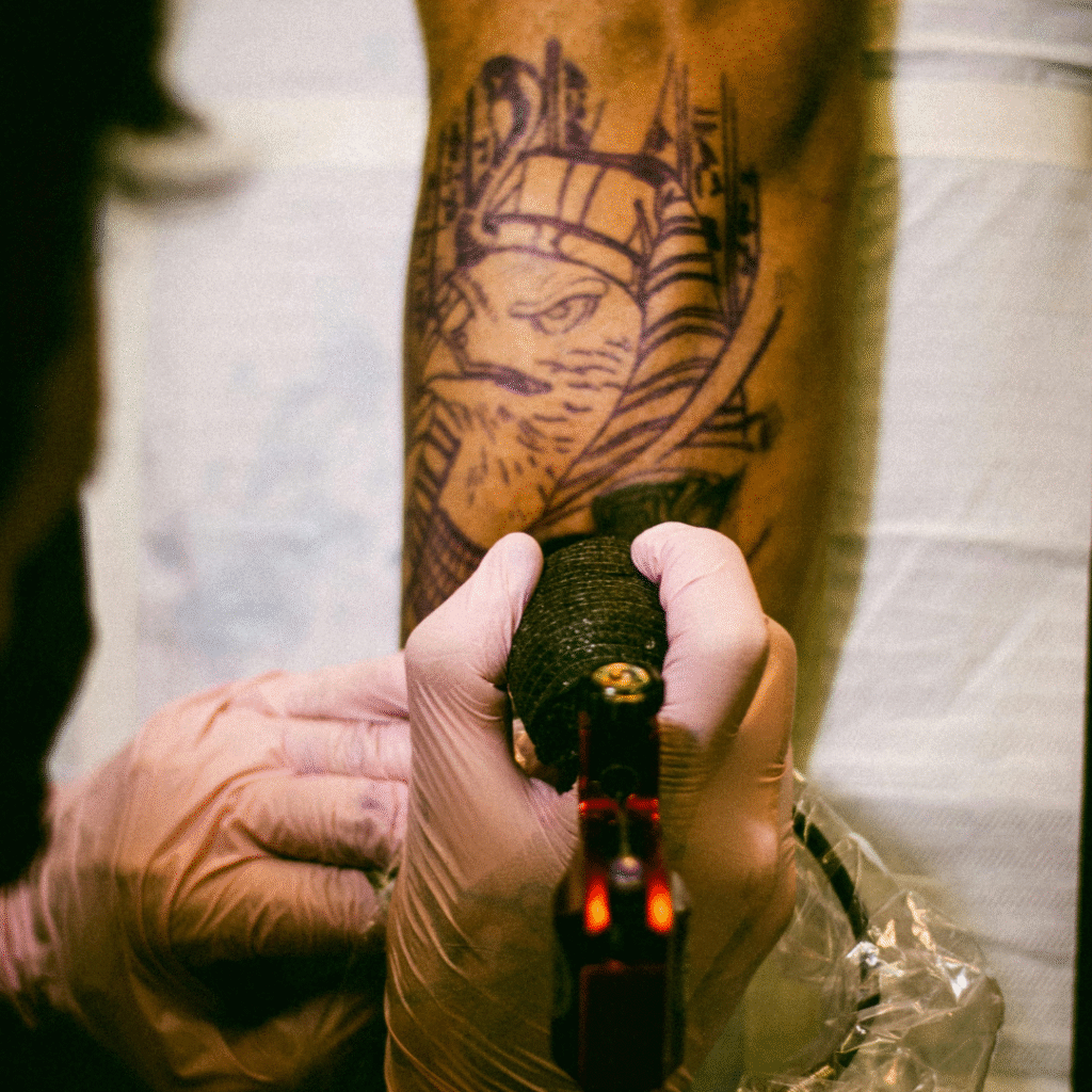 Tattoo artist tattooing a client’s forearm—showing how tattoo booking mistakes can waste valuable chair time.