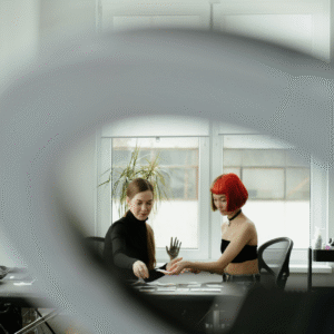 Tattoo artist reviewing booking cards with a red-haired client in a bright studio, illustrating clear appointment boundaries.