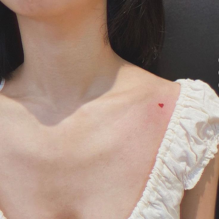 Tiny tattoos marketing featuring minimalist red heart tattoo on shoulder