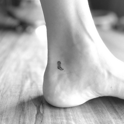 Tiny minimalist boot tattoo symbolizing freedom and journey – tattoo symbolism in pop culture 2025