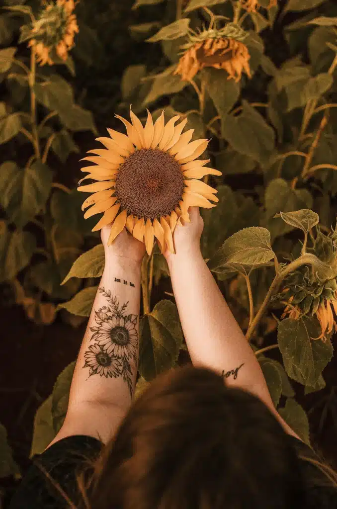 Sunflower tattoo on arm with warm autumn tones – nature-inspired fall tattoo trends 2025