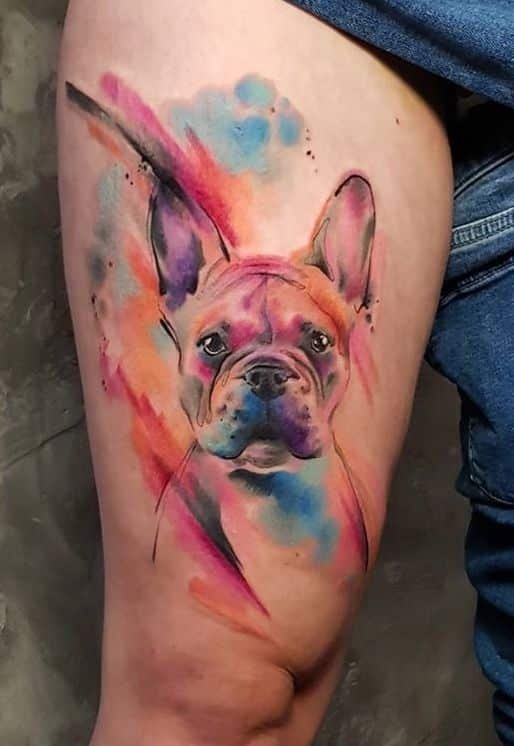 watercolor french bulldog tattoo with pink blue and orange splashes on thigh