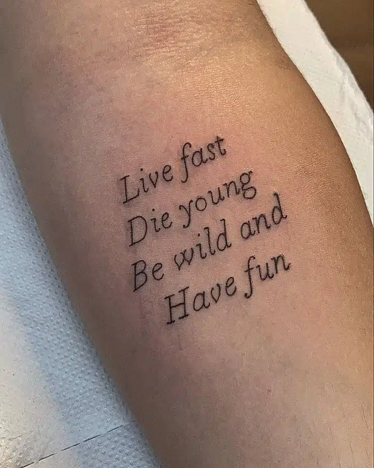 lyric line tattoo in cursive font on forearm for music lovers
